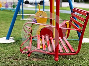 Red iron swing and yellow swing shape duck Set in a playground.