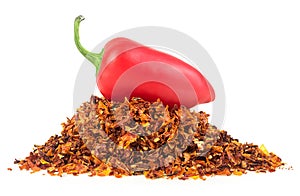 Red jalapeno pepper and pile of dried chili pepper flakes isolated on white background