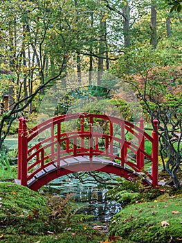 Red Japanese bridge in an autumn garden