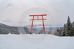 Red Japanese Torii pole, Fuji mountain and snow in Kawaguchiko, Japan. Forest trees nature landscape background in winter season