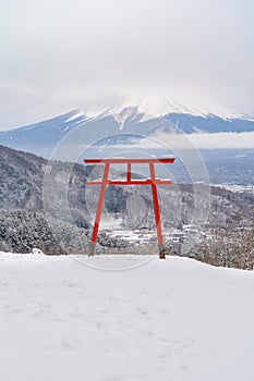 Red Japanese Torii pole, Fuji mountain and snow in Kawaguchiko, Japan. Forest trees nature landscape background in winter season