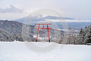 Red Japanese Torii pole, Fuji mountain and snow in Kawaguchiko, Japan. Forest trees nature landscape background in winter season