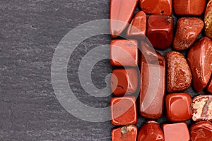 Red jasper heap stones texture on half black stone background. Place for text