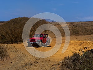 Red Jeep going through rough road