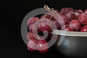 Red juicy fresh grapes with metal plate healthy snack on dark background