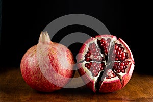 Red juicy pomegranate fruit on wooden table