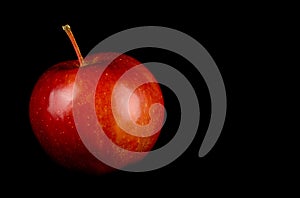 Red, juicy ripe apple on a black background close-up