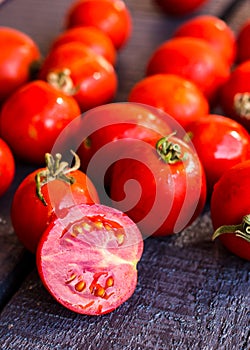 Red juicy tomatoes cherry on dark wooden board