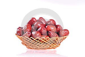 Red jujubes in a basket on white