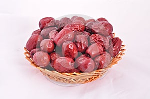 Red jujubes in a basket on white