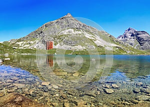 The red Julier Theater Tower on the Julier Pass (2284 m above sea level) with reflection photo