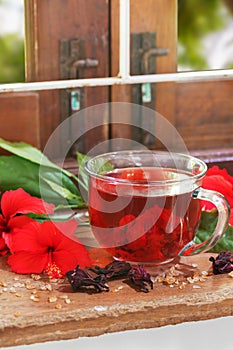 Red karkade hibiscus red sorrel tea in glass mug with dry tea cu
