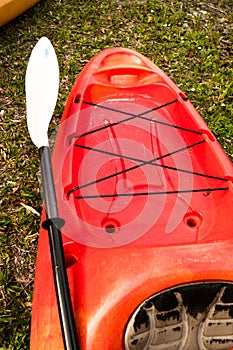 Red kayak and white paddle close up