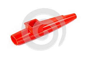 Red kazoo, plastic traditional musical instrument object isolated on white, cut out, closeup. Kids wind instruments with vibrating