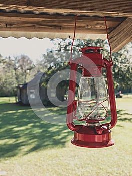 Red kerosene lantern hanging on the roof of a porch