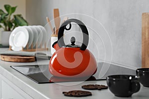 Red kettle with whistle on cooktop in kitchen