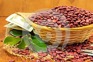 Red Kidney beans in a small woven basket on an artesan weave fabric, twenty USD bills photo