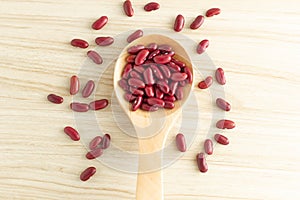 Red kidney beans and spoon on wooden background, top view, flat lay, top-down, selective focus.copy space