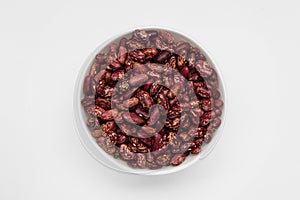 Red kidney beans in white bowl view from above isolated white background