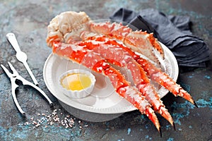 Red king crab legs with butter sauce on a plate