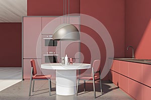 Red kitchen interior with table and chairs on concrete floor
