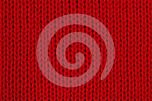 Red knitted fabric macro photo. Detail of clothes as a red background