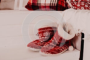 Red knitted sock with ornaments rustic Christmas decor. New year, comfort, warmth