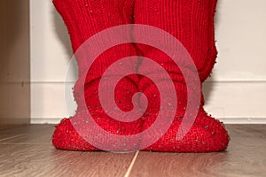 Red knitted socks of rough wool on the feet