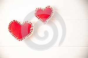 Red knitted soft fabric hearts on white background