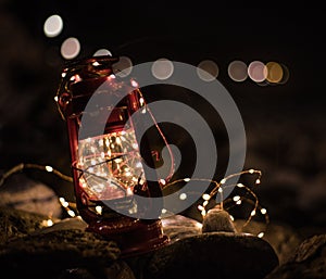 Red lantern with garlands on beach stones in dark night of Marbella, Malaga