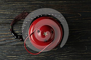 Red lantern and rosary on wooden table, top view