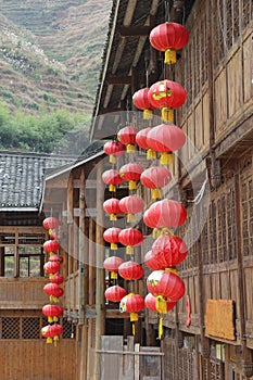 Red happy lanterns at ancient wooden houses, Dazhai / Longsheng, China photo