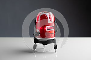 Red laser level tool on grey background