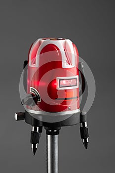 Red laser level tool on grey background