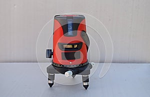 Red laser level tool on grey background