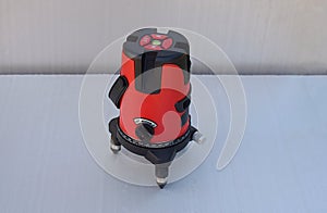Red laser level tool on grey background