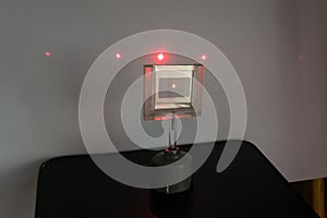 Red laser light passes through a grating, causing diffraction