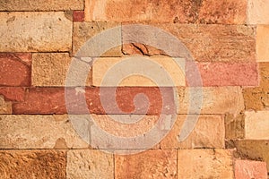 Red laterite stone wall texture background.