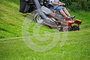 Red Lawn mower cutting grass. Gardening process of lawn mowing