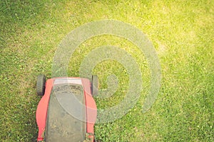 Red Lawn mower cutting green grass/red Lawn mower cutting green grass. Top view and copyspace