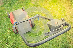 Red lawn mower on a green lawn/red lawn mower on a green lawn. Top view