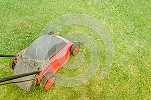 Red lawn mower on the lawn/red lawn mower on the lawn. Top view