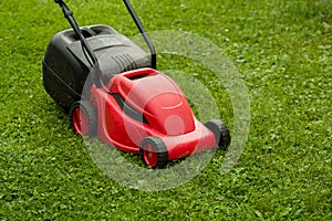 Red lawnmower on green grass