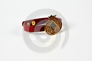 Red leather and gold cuff bracelet on white background with copy space