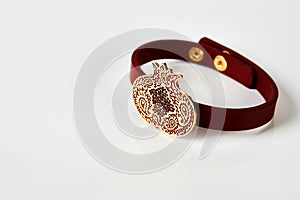 Red leather and gold cuff bracelet on white background with copy space