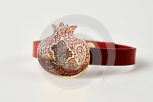 Red leather and gold cuff bracelet on white background with copy space