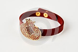 Red leather and gold cuff bracelet on white background with copy space