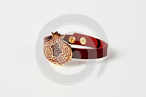 Red leather and gold cuff bracelet on white background with copy space