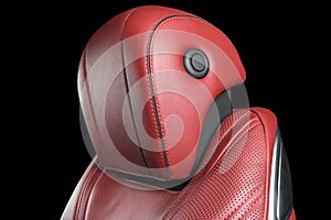 Red leather interior of the luxury modern car. Perforated red leather comfortable seats with stitching isolated on black backgroun