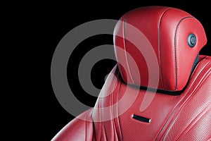 Red leather interior of the luxury modern car. Perforated red leather comfortable seats with stitching isolated on black backgroun